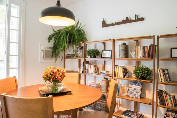 Estantes de madeira para sala piccolo nozes ambientadas em local de leitura com livros nas prateleiras