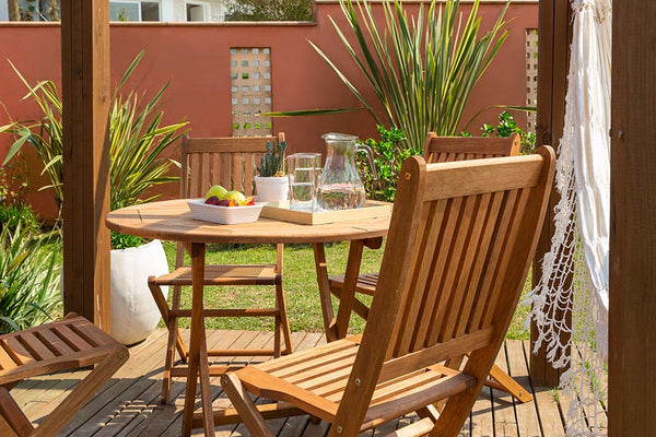 cadeira de piscina dobravel jatoba vista de tras em jardim com mesa dobravel