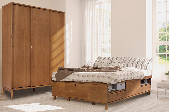foto ambientada da cama casal charme doce de leite escovado vista na diagonal com colchao colcha e travesseiro e guarda roupa charme aos fundos