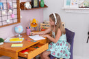 foto ambientada da escrivaninha multifuncional 120 duna cerezo vista parcial com obejtos sobre o tampo com menina estutando