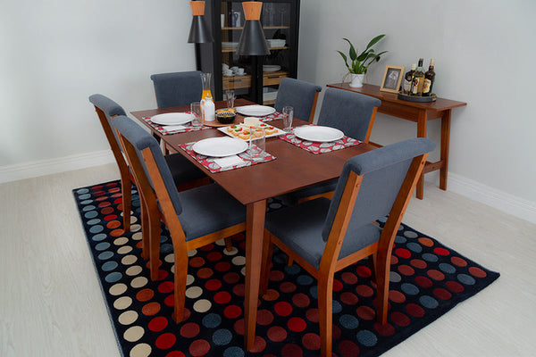 foto ambientada da mesa de madeira jantar 6 lugares lotus caramelo vista na diagonal com 6 cadeiras e loucas sobre o tampo