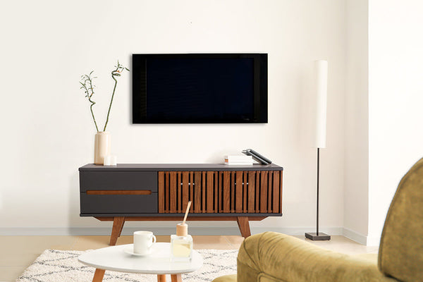 foto ambientada de sala de estar com rack de sala para tv 1,65 m panteon grafite visto de frente com objetos sobre rack e tv fixada na parede