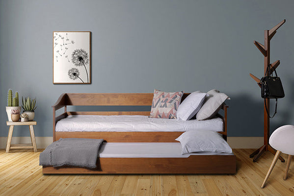 foto ambientada do sofa bicama flora caramelo visto de frente com colchao lencol e travesseiro e cama debaixo aberta e cabideiro ao lado
