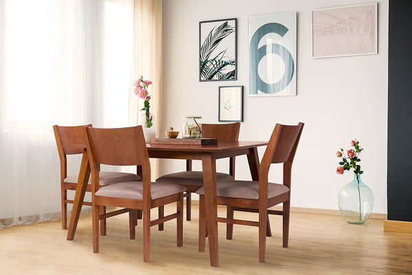 foto ambientada mesa de madeira 4 lugares lotus caramelo com 4 cadeiras estofadas lotus caramelo com objetos sobre o tampo