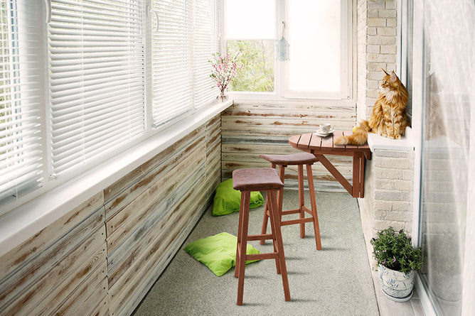 foto ambientada mesa para varanda redonda dobravel legno jatoba vista pela lateral fixada na parede com gato sobre ela aberta em varanda coberta