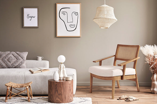 foto ambientada poltrona decorativa vitrola nozes e tecido bege vista na diagonal com parede ao fundo bege e sofa ao lado