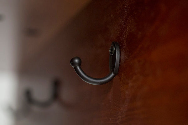 foto do espelho de quarto chao com cabide caramelo focando nos ganchos