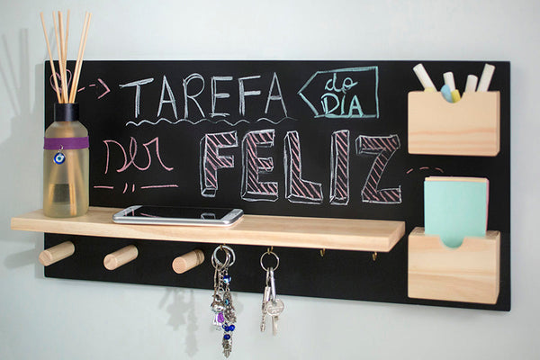 foto ambientada do painel de recados e porta chaves mdf chat cru e preto visto na diagonal com objetos e recado escrito no quadro com giz