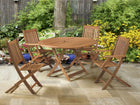 foto ambientada mesa rustica redonda 120 dobravel jatoba aberta vista de frente com 4 cadeiras dobraveis envolta no jardim