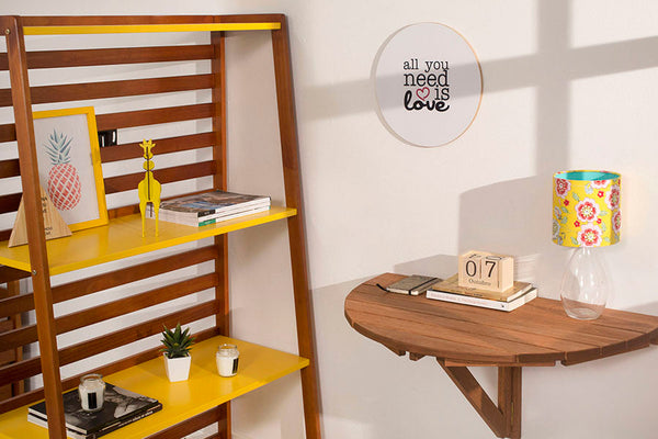 mesa para cozinha dobrável de parede legno jatobá vista pela lateral fixada na parede com objetos sobre ela e estante ao lado